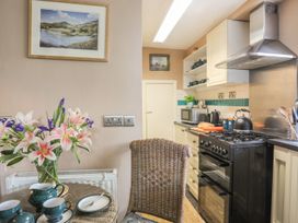 A kitchen with flowers on a table at Ty Gwenno in Criccieth