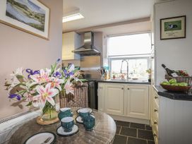 A kitchen with a table set for tea at Ty Gwenno in Criccieth