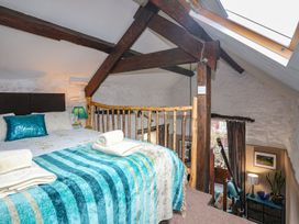 A bedroom with a bed and wooden bannister at Ty Gwenno in Criccieth