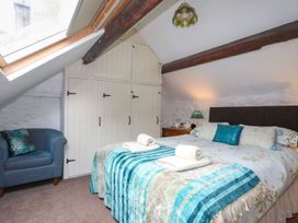A bedroom with a bed and wardrobe at Ty Gwenno in Criccieth