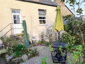 A garden with a table and umbrella at Ty Gwenno in Criccieth
