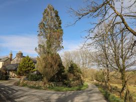 A house with a driveway and trees at Ty Gwenno in Criccieth