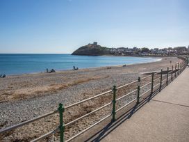 A beach with people near the water at Ty Gwenno Criccieth