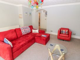 A living room with a red sofa and coffee table at The Hideaway in Whitby