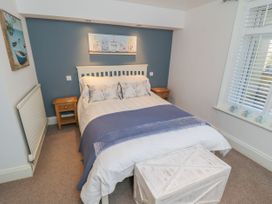 A bedroom with a bed and nightstand at The Hideaway in Whitby