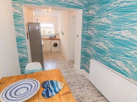 A kitchen with a table and refrigerator at The Hideaway in Whitby