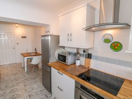 A kitchen with appliances and dining table at The Hideaway in Whitby
