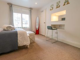 A bedroom with a bed, desk, and mirror at The Hideaway in Whitby