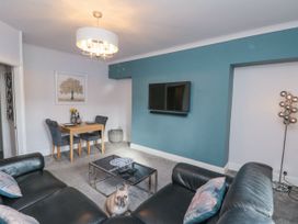 A living room with a couch and dining area at Cuckoo's Nest in Whitby