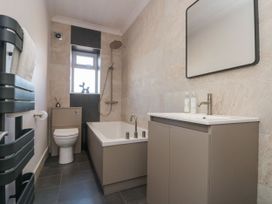 A bathroom with a bathtub, toilet, and sink at Cuckoo's Nest in Whitby