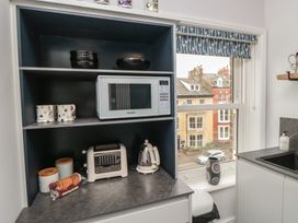 A kitchen with a microwave and toaster on a shelf at Cuckoo's Nest in Whitby