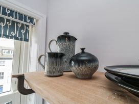 A teapot, milk jug, and sugar bowl on a wooden shelf at Cuckoo's Nest in Whitby