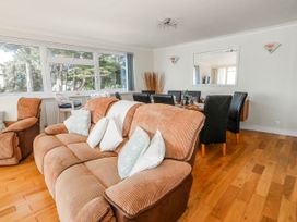 A living room with a sofa and a dining table at Flat 17 Golden Gates in Poole