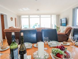 A dining area with a table set and a sofa at Flat 17 Golden Gates in Poole