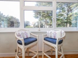 A sunroom with two chairs and cushions at Flat 17 Golden Gates in Poole