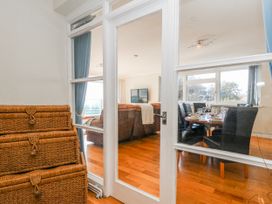A dining room with a table and chairs visible through a glass door at Flat 17 Golden Gates in Poole
