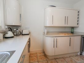 A kitchen with a kettle, toaster, and cutting board at Flat 17 Golden Gates in Poole