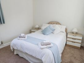 A bedroom with a bed and nightstands at Flat 17 Golden Gates in Poole