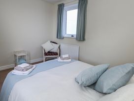 A bedroom with a bed and a chair at Flat 17 Golden Gates in Poole