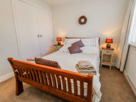 A bedroom with a bed and nightstands at Flat 17 Golden Gates in Poole