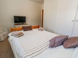 A bedroom with a bed, television, and towels at Flat 17 Golden Gates in Poole