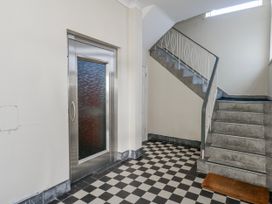 A hallway with an elevator and staircase at Flat 17 Golden Gates in Poole