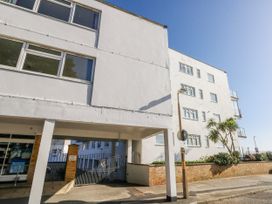 An apartment building with a gate and parking area at Flat 17 Golden Gates in Poole