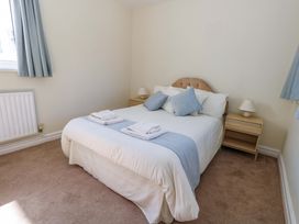 A bedroom with a bed and nightstands at Flat 17 Golden Gates Sandbanks
