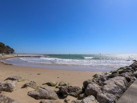 A beach with waves and rocks at Flat 17 Golden Gates Sandbanks