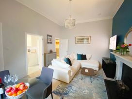 A living room with a sofa, table, and television at 2A Redcliffe in Torquay