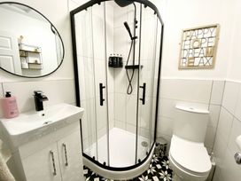 A bathroom with a shower enclosure, sink, and toilet at 2A Redcliffe in Torquay