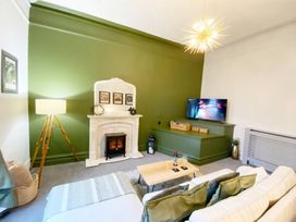 A living room with a sofa, coffee table, and television at 2B Redcliffe in Torquay