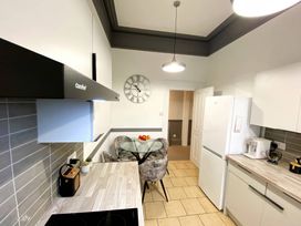 A kitchen with a refrigerator and table at 2B Redcliffe in Torquay