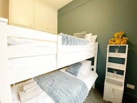A bedroom with a bunk bed and shelves at 2B Redcliffe in Torquay