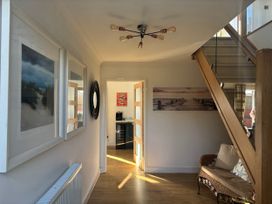 A hallway with a staircase and framed pictures at Seaview in Pakefield