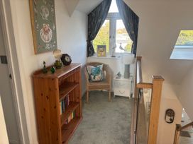 A hallway with a bookcase and chair at Seaview in Pakefield