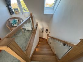 A staircase with a window and a chair at Seaview in Pakefield