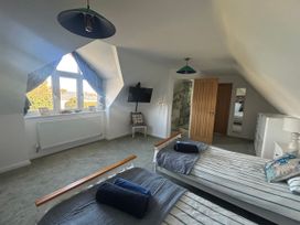 A bedroom with twin beds and a wall-mounted TV at Seaview in Pakefield
