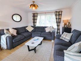 A living room with a sectional sofa and coffee table at Seaview in Pakefield