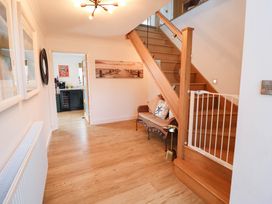 A hallway with a staircase and a bench at Seaview in Pakefield