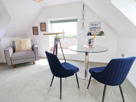 An attic room with a glass table and chairs at Seaview in Pakefield