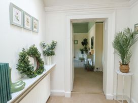 A hallway with plants and artwork at Castle Gardens Apartment in Beaumaris