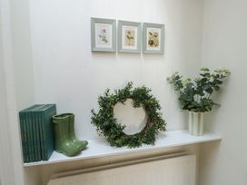 A hallway with books and a green boot at Castle Gardens Apartment Beaumaris