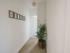 A hallway with framed art and a plant at Castle Gardens Apartment Beaumaris