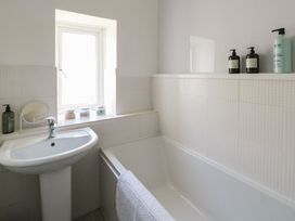 A bathroom with a sink and tub at Castle Gardens Apartment Beaumaris