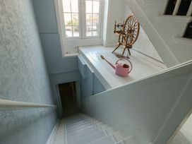 A staircase with a spinning wheel and a watering can at Castle Gardens Apartment Beaumaris