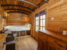 A bedroom with a bed and wooden furniture at The Damselfly