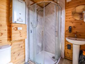 A bathroom with a shower, sink, and toilet at The Damselfly