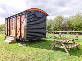 A tiny house with steps and picnic table at The Damselfly