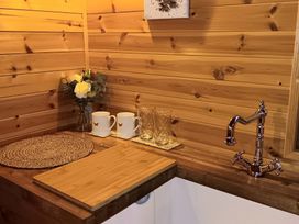 A kitchen corner with a sink, cutting board, mugs, and glasses at The Damselfly Bewholme near Hornsea